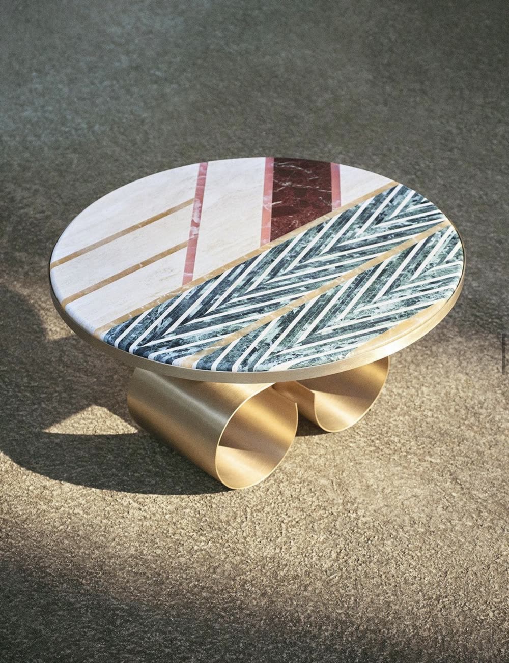 Mesa escultórica de piedra y metal bajo luz natural